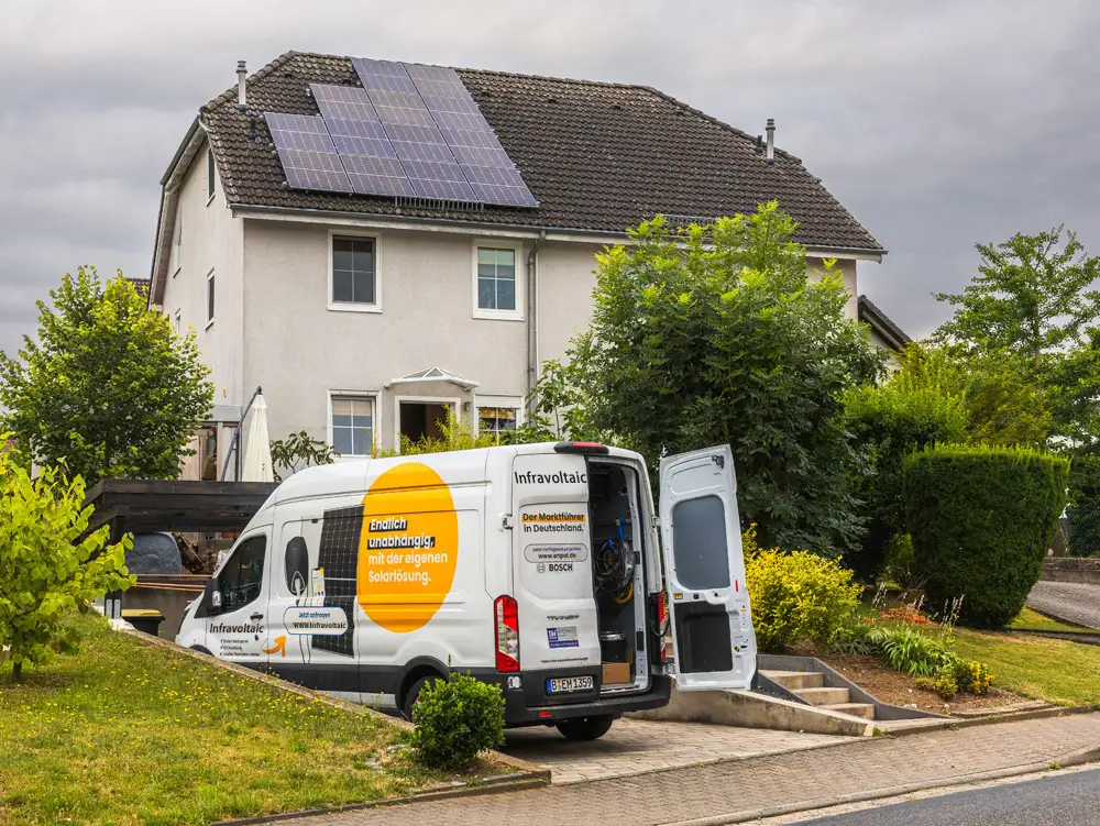 Infravoltaic-Van vor einem Haus mit Solaranlage